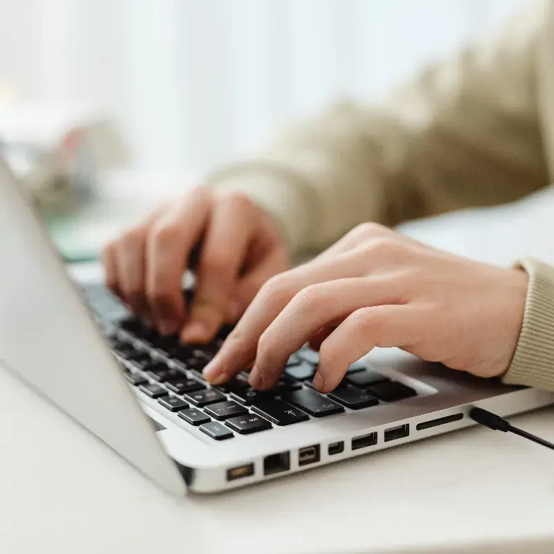 Handen die op een laptop typen